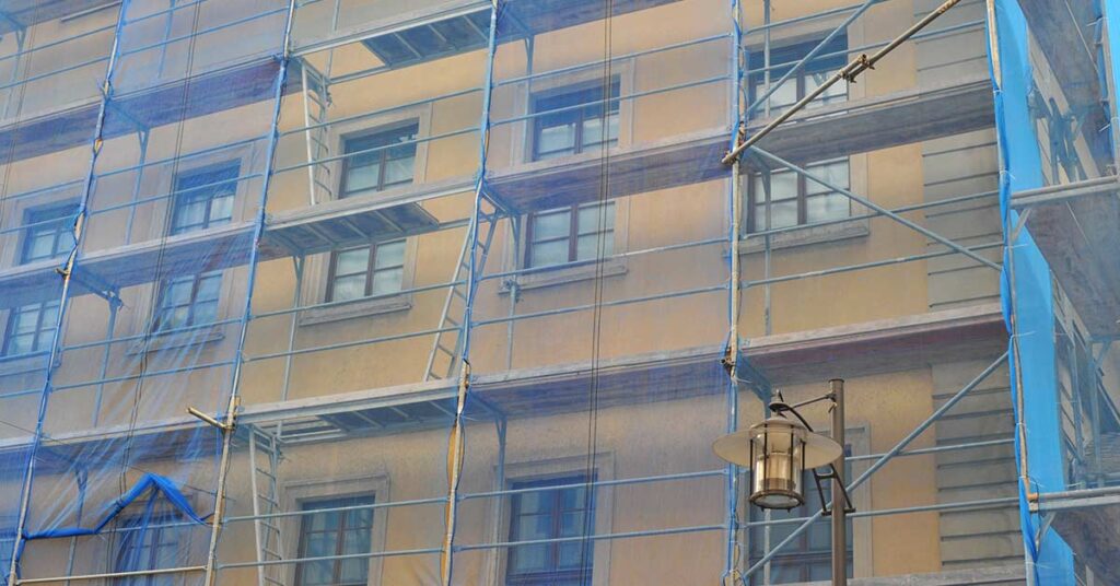 Gerüst ist vor einem Altbauhaus aufgebaut, damit es saniert werden kann.